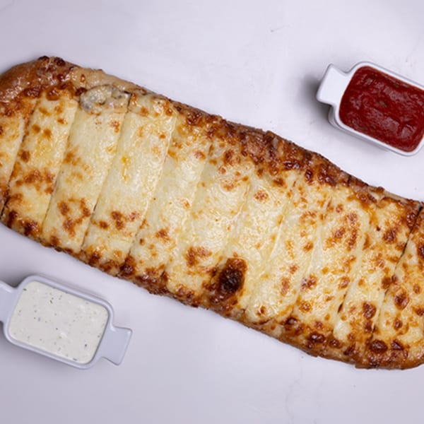 Long, rectangular cheesy breadsticks with two dipping sauces, one red and one white.