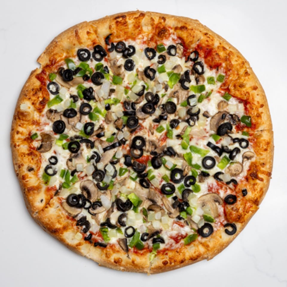 A whole Pizza Place pizza topped with black olives, green peppers, onions, and mushrooms.
